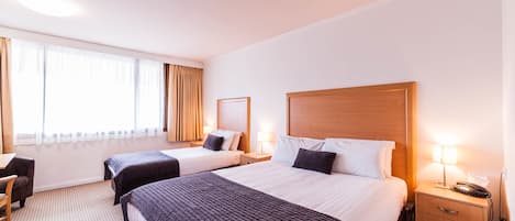 Minibar, escritorio, tabla de planchar con plancha y ropa de cama