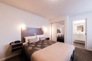 Minibar, escritorio, tabla de planchar con plancha y ropa de cama