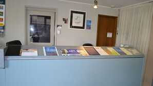 A reception desk with informational brochures and a framed picture on the wall.