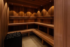 A sauna with wooden benches and a bench with a black container.