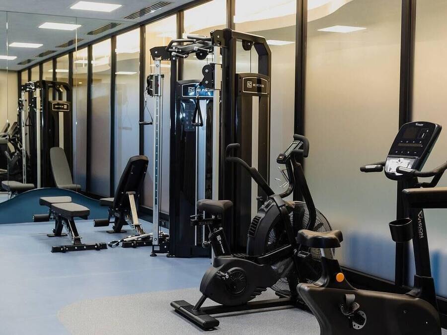 Une salle de sport équipée de matériel d’exercice, d’un tapis de course et d’un vélo d’appartement.