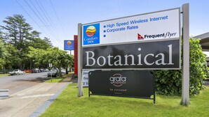 A signboard for a Comfort Inn with amenities like high-speed wireless internet, corporate rates, and frequent flyer programs. - Botanical Motel (Hamilton)