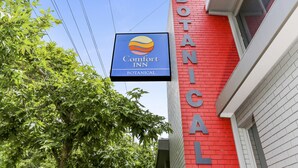 A Comfort Inn sign on a red building with the word "BOTANICAL" on the side. - Botanical Motel (Hamilton)