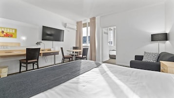 Minibar, escritorio, cortinas blackout y tabla de planchar con plancha