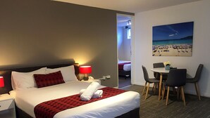 Una habitación de hotel con cama, escritorio y silla.