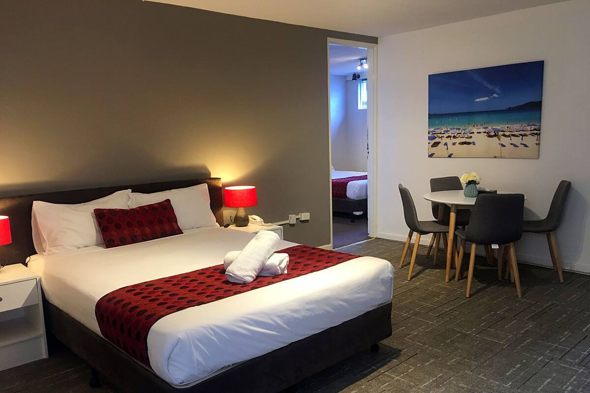A hotel room with a bed, a desk, and a chair.