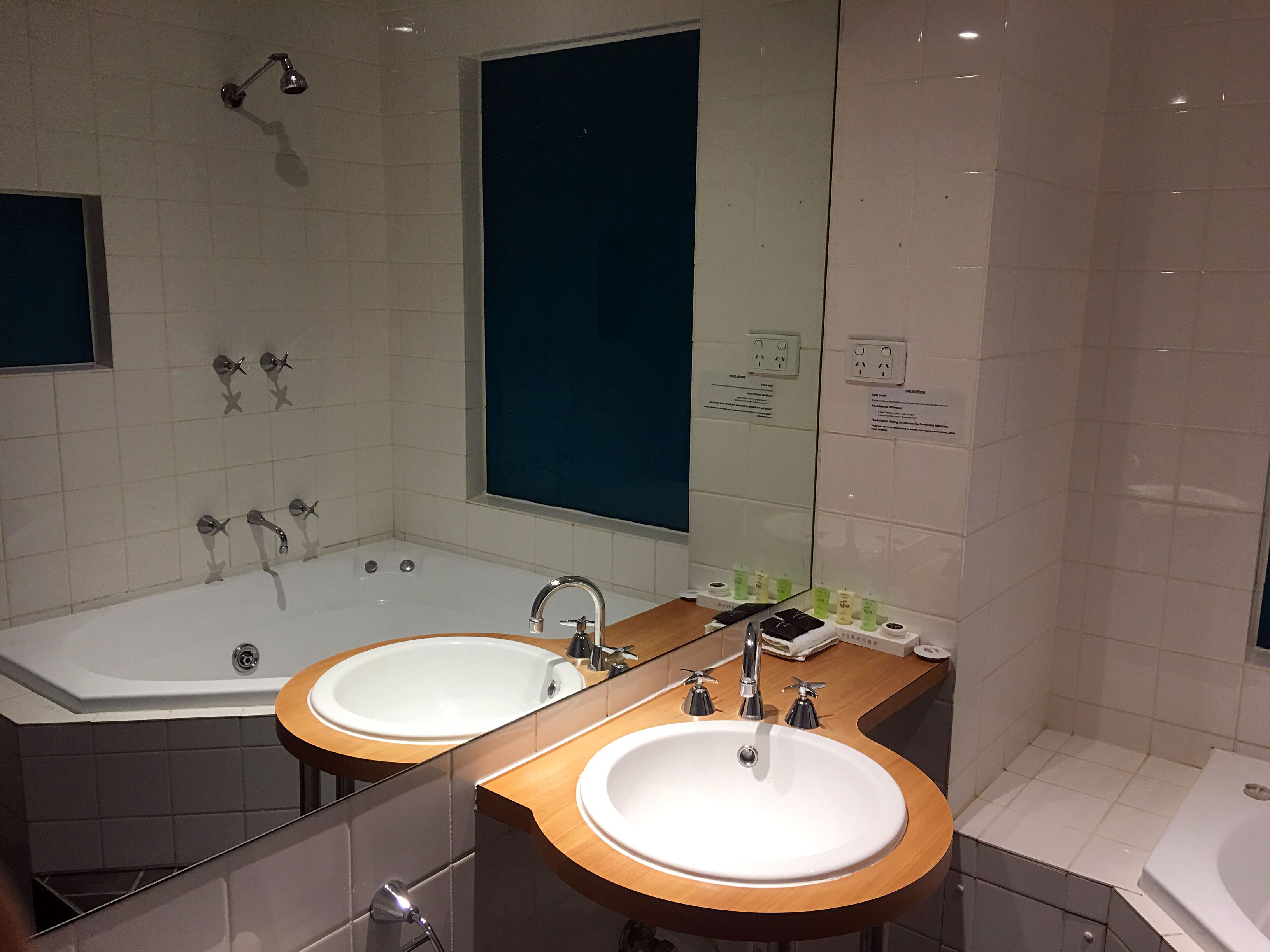 Un baño moderno con lavamanos doble, una bañera grande y una ducha.