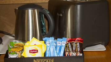 Ein Tablett mit Nescafé Kaffeekapseln, Lipton Teebeuteln und einem Wasserkocher.