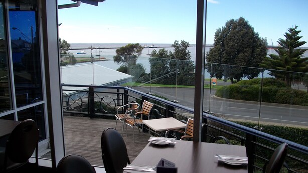 A restaurant with a view of a road and trees.