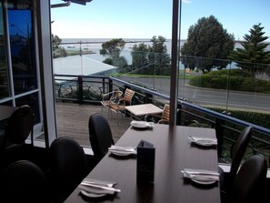 A restaurant with a view of a road and trees. - Richmond Henty Hotel (Portland)