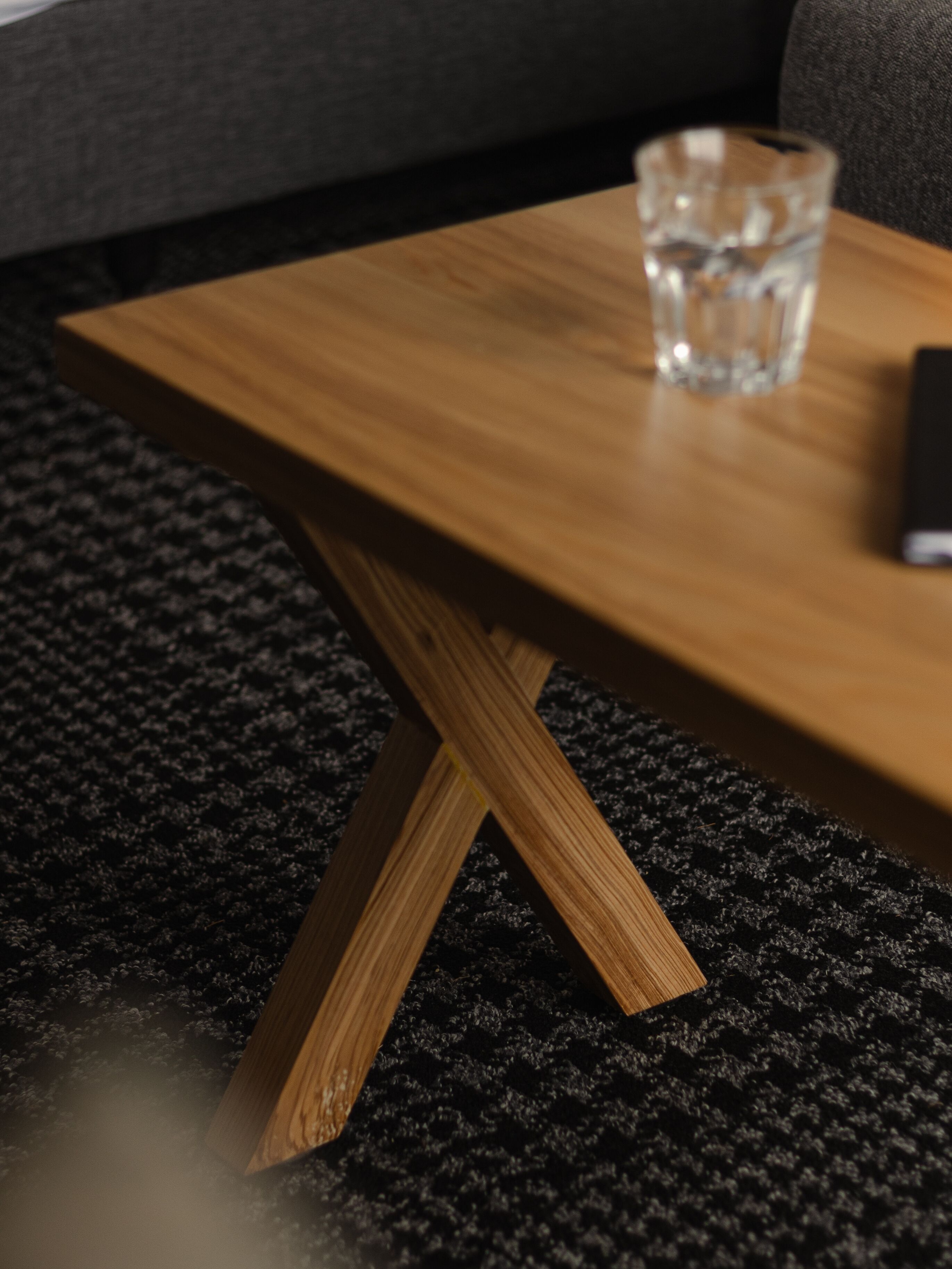 Une table en bois sur laquelle se trouve un verre d’eau.
