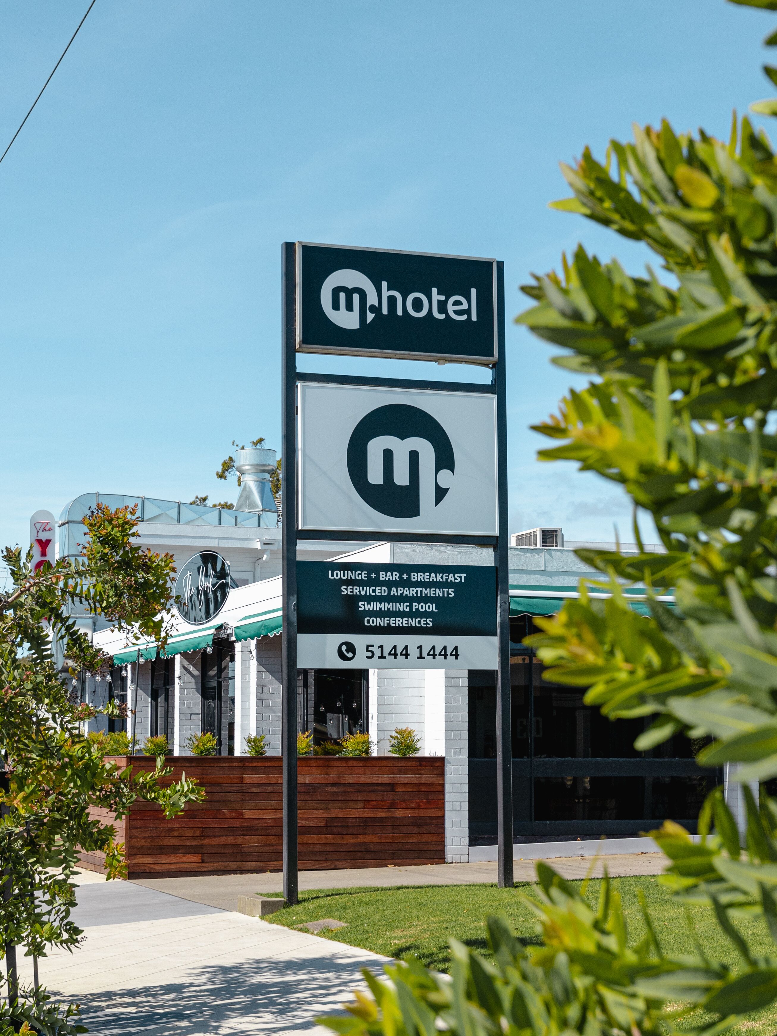Letrero de hotel que ofrece servicios como salón, bar, desayuno, apartamentos con servicio, piscina y salas de conferencias.