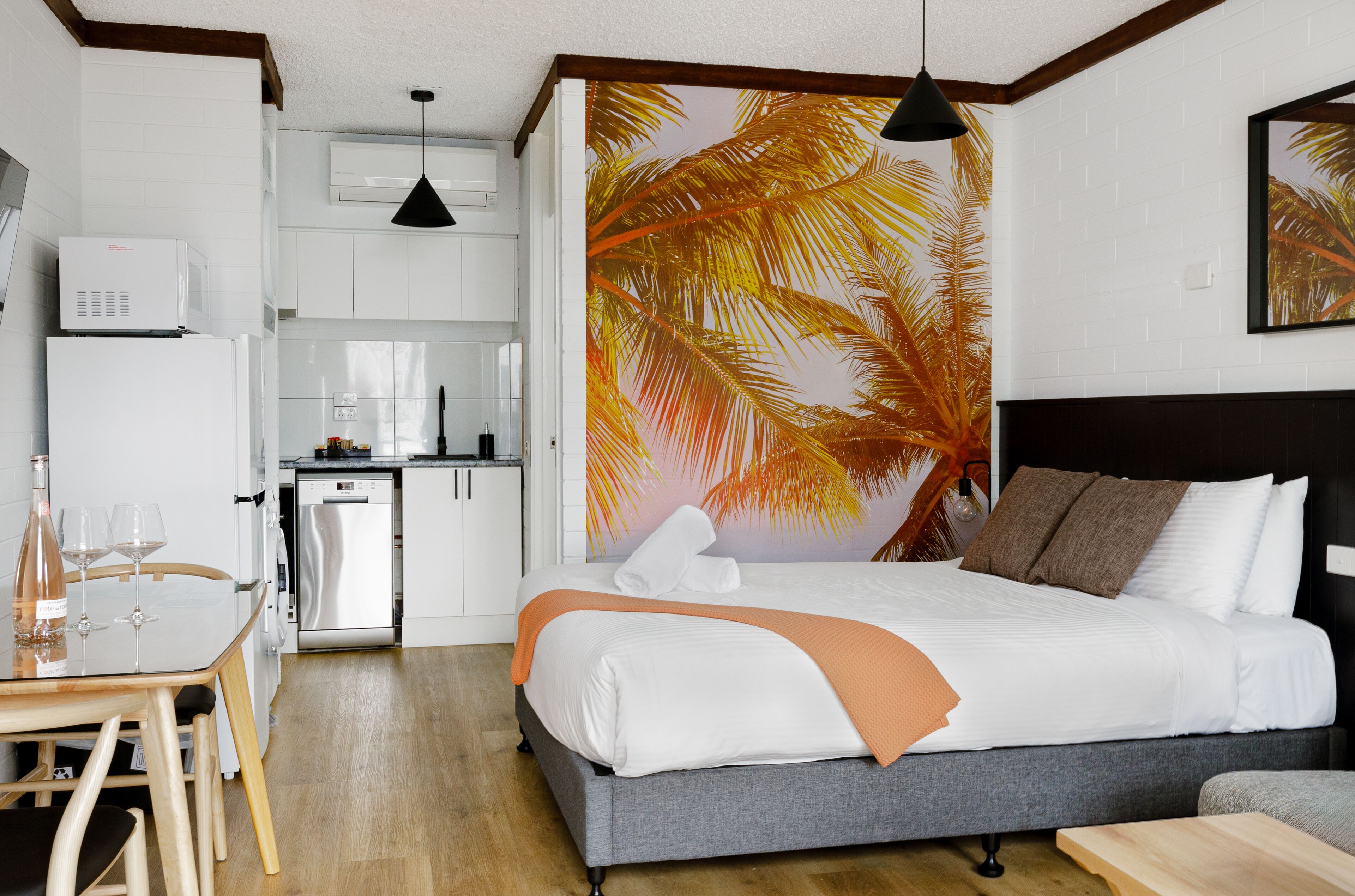 Una habitación de hotel con una cama, una mesa de comedor y una zona de cocina.