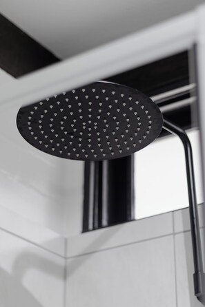 A modern showerhead with a black, perforated design.