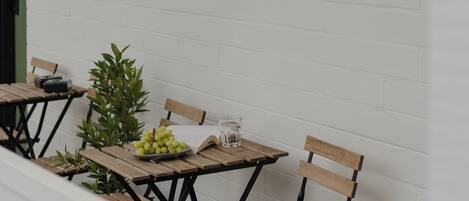 A table set with a bowl of green grapes, a glass of water, and an open book.