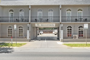 A hotel reception with a double entrance, outdoor seating, and a fenced parking area. - Sherbourne Terrace Hotel (Shepparton)
