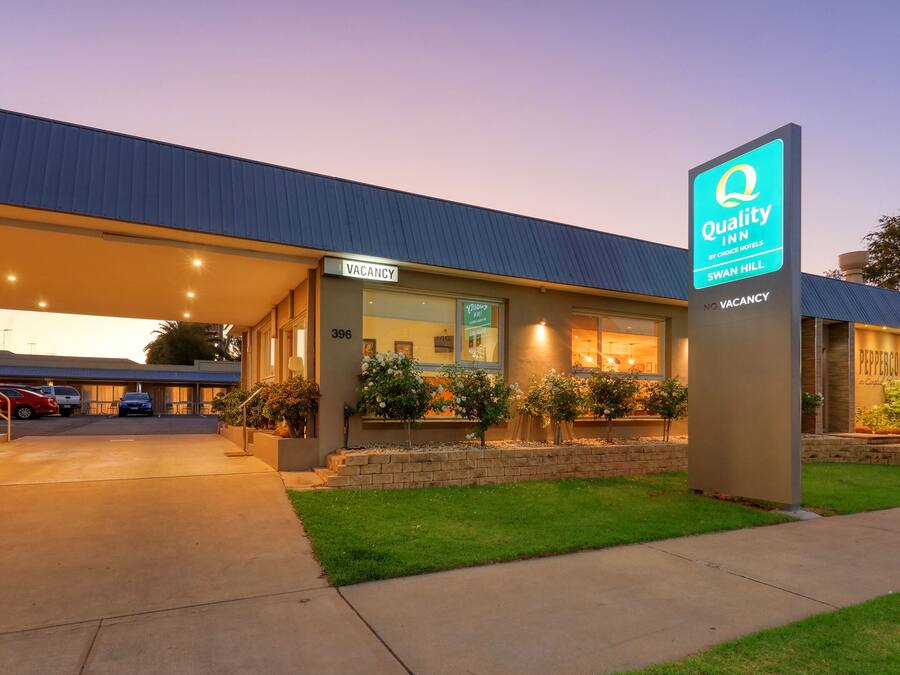 Un hôtel avec une pancarte indiquant « Chambres disponibles », une pancarte « Quality Inn by Choice Hotels » et une pancarte « Peppercorn ».