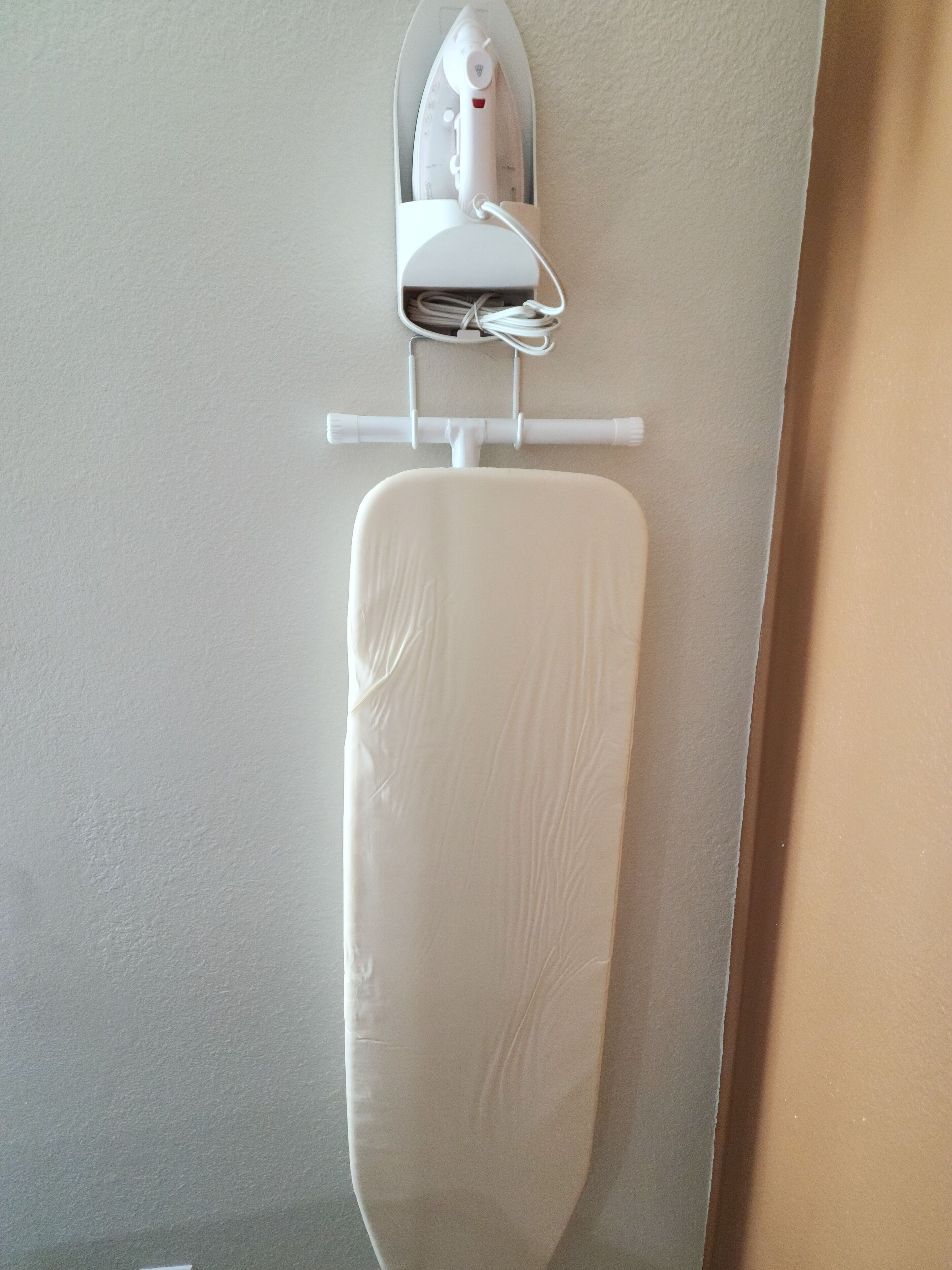 A wall-mounted ironing board with an iron.