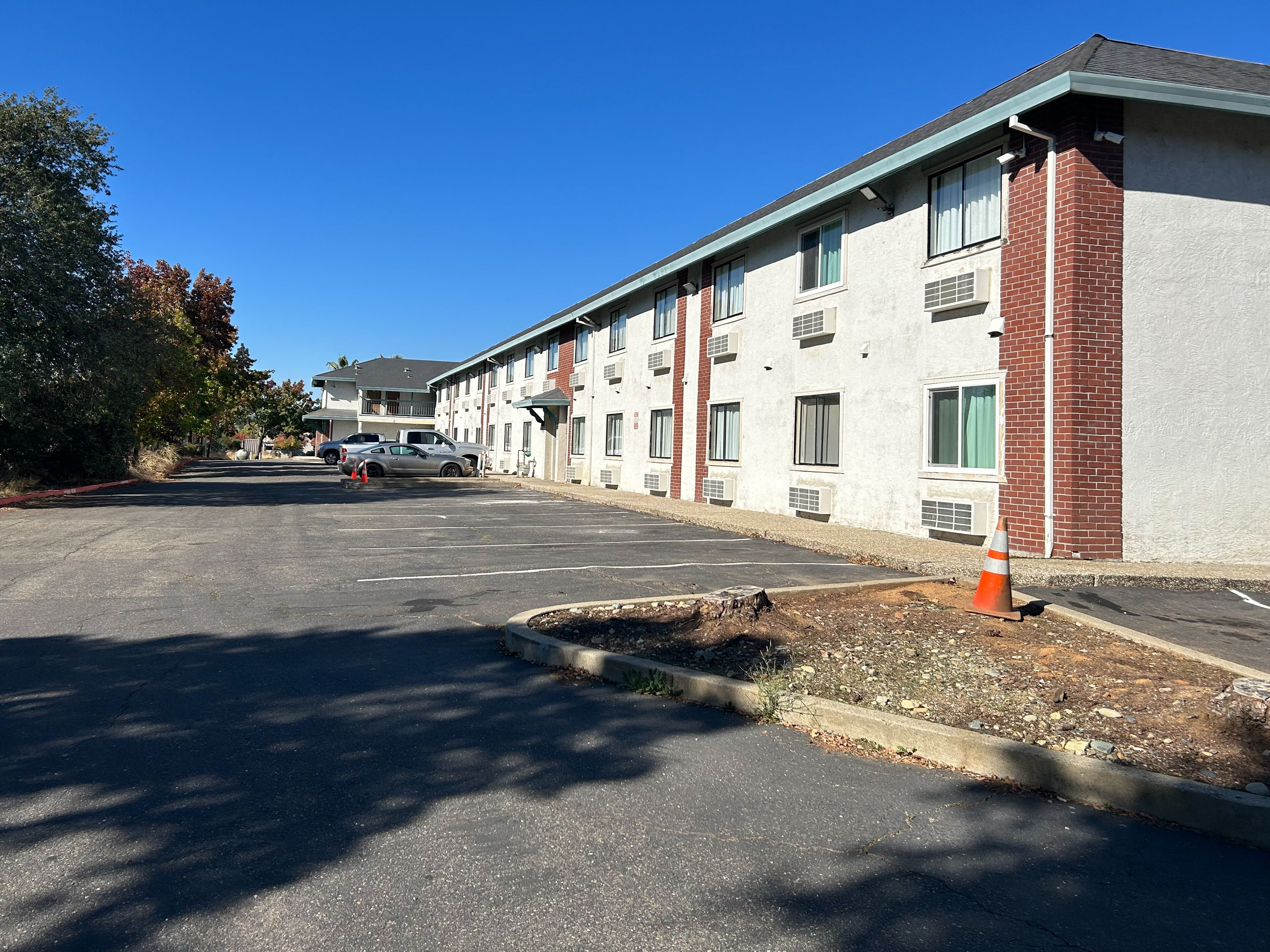 A multi-story motel with a parking lot.