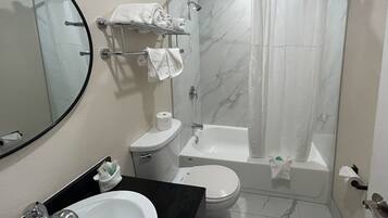 A bathroom with a toilet, sink, and bathtub.
