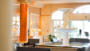 A lobby with a large column, a fountain, and seating areas. - Hotel Grand Chancellor Launceston (Launceston)