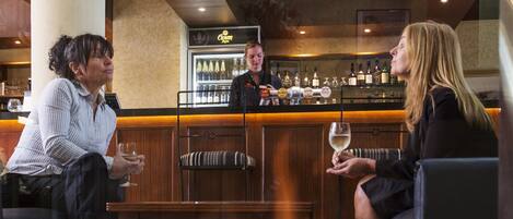 A bar area with a fire feature, seating, and a bar counter with bottles.