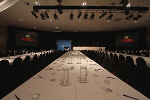A conference room with a long table, chairs, and a stage with a podium.