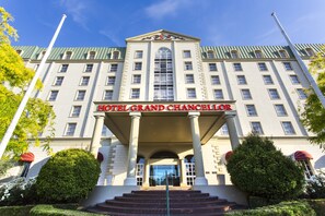 Experience the grand entrance of Hotel Grand Chancellor, featuring a symmetrical facade and central arched window.