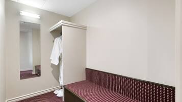 Relax in a cozy space with a single bed, full-length mirror, and convenient robe hook.