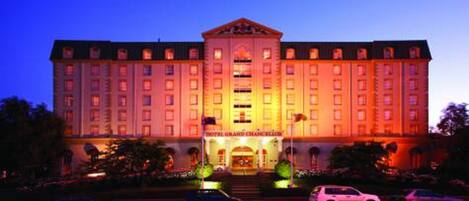 A large hotel building with a central entrance, multiple floors, and a symmetrical facade.
