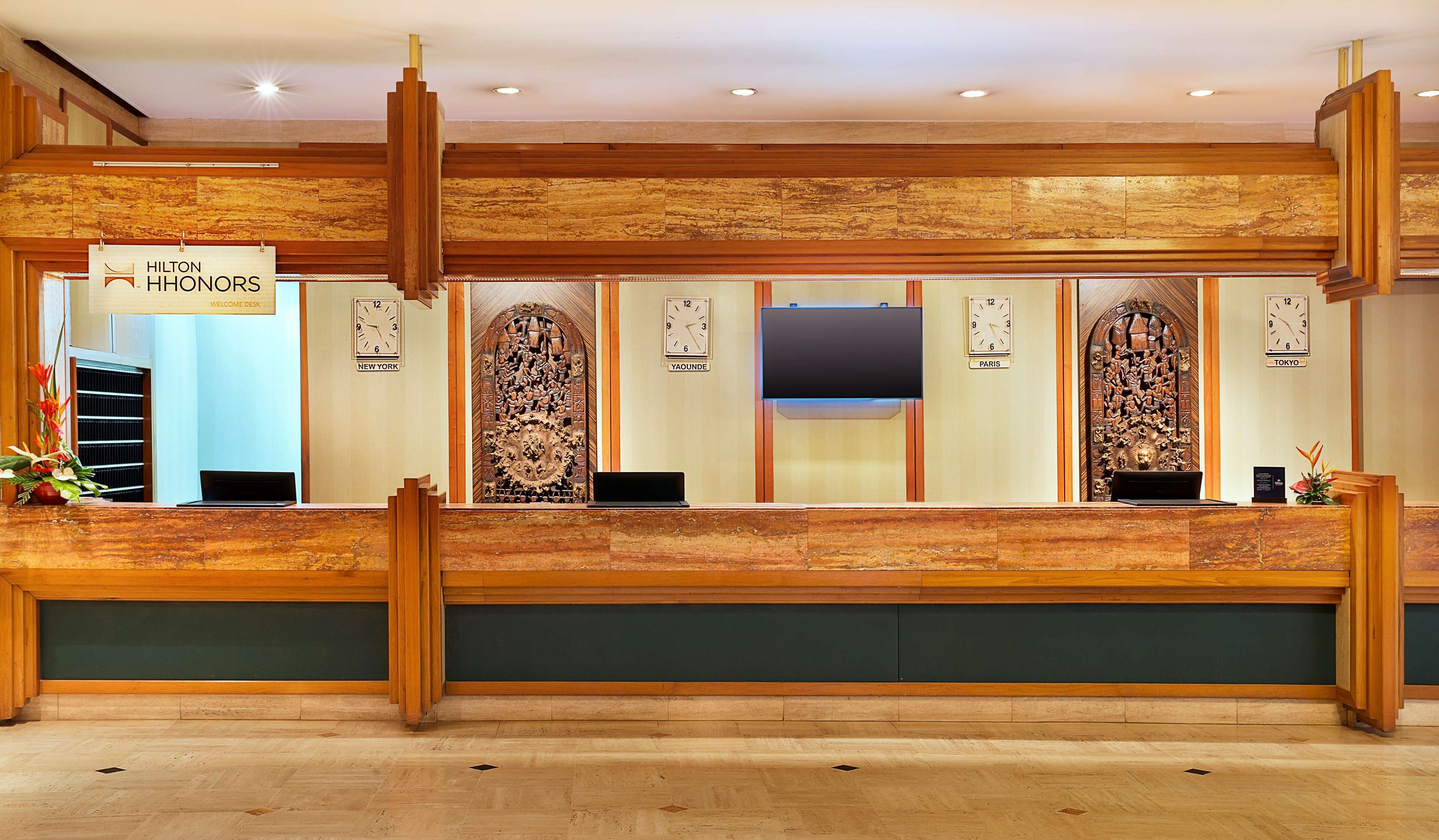 A reception desk with clocks indicating New York, Paris, and Tokyo times.