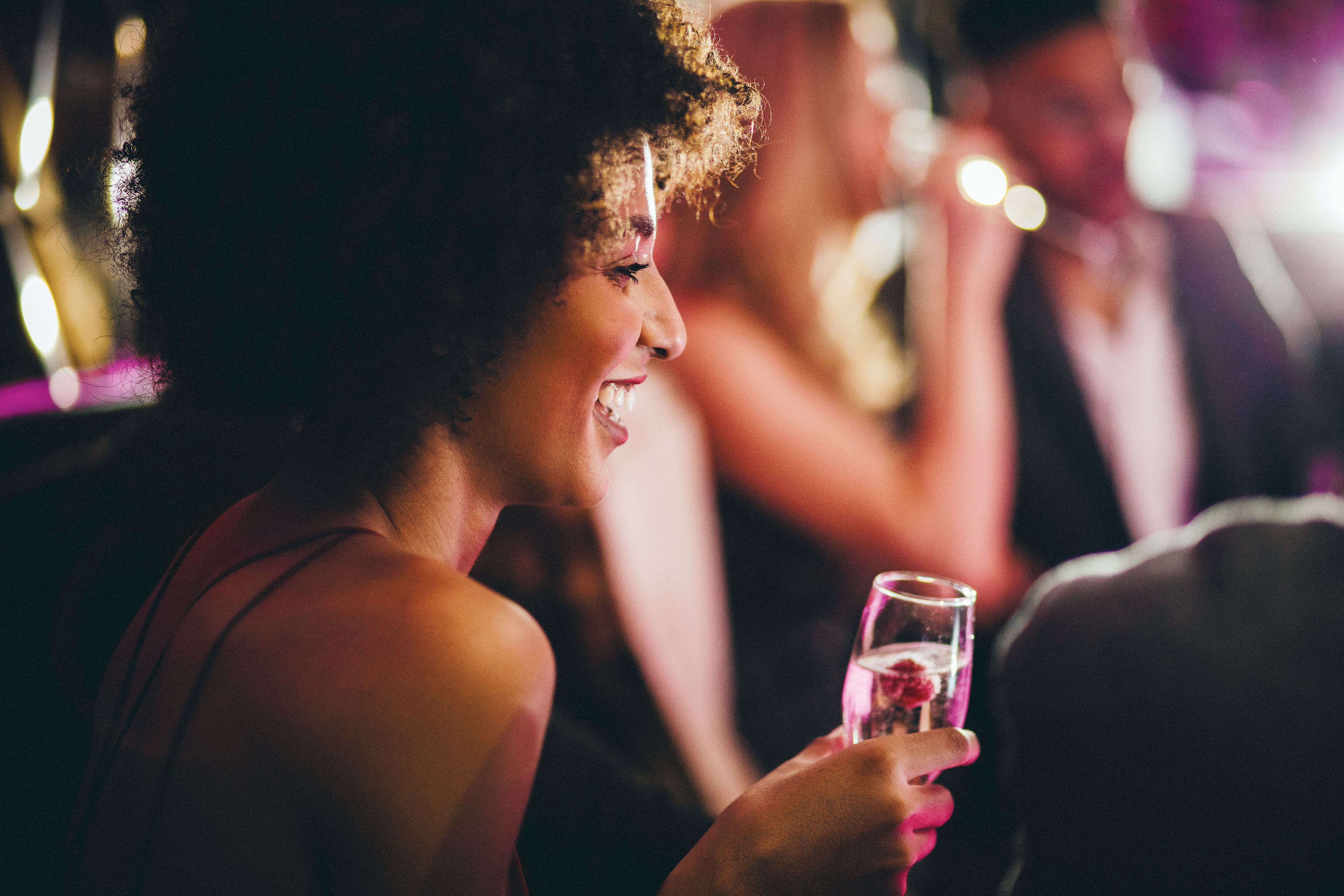 A person holding a glass, likely at a social event.