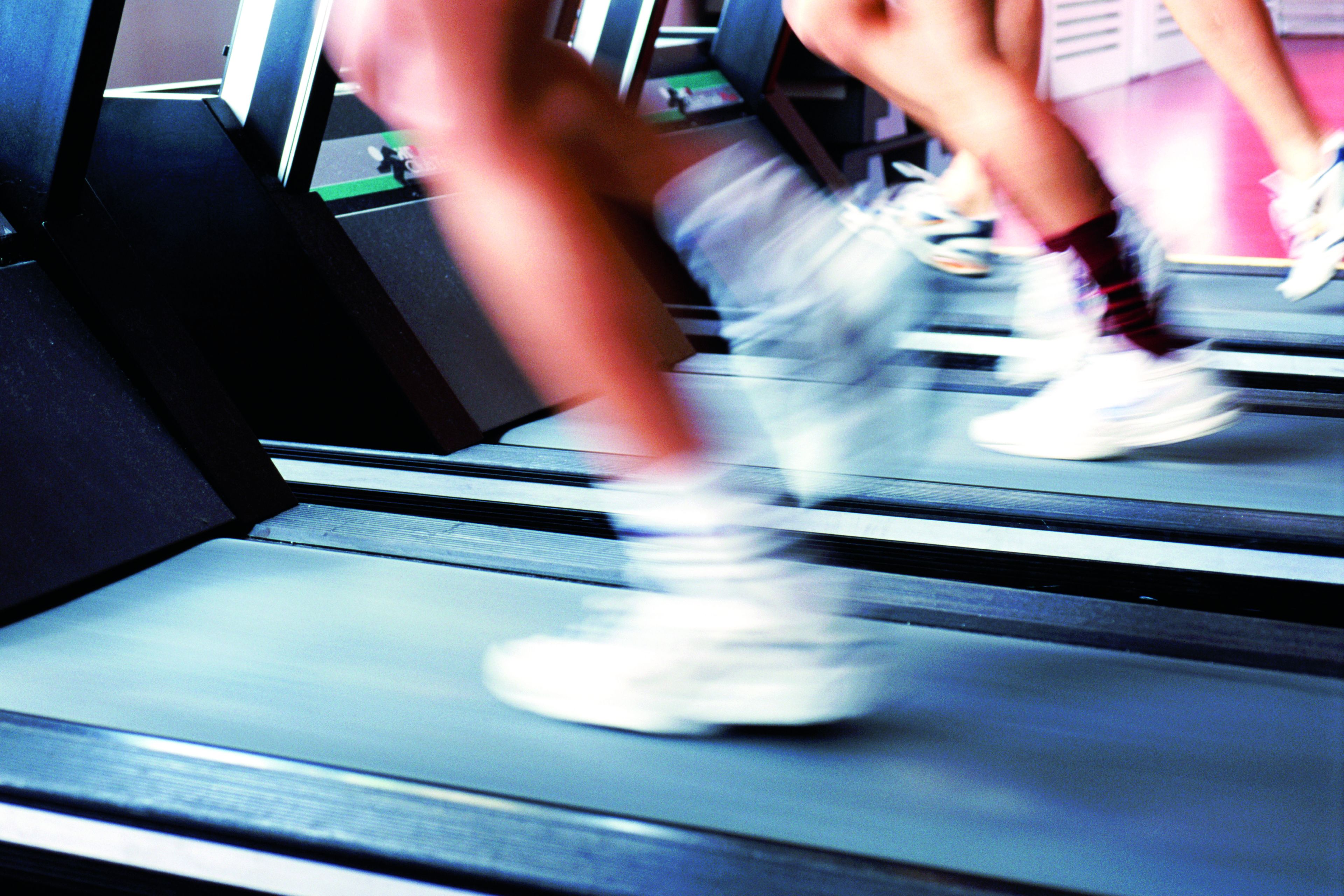 A blurred view of a treadmill with a person running.
