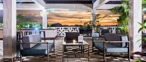 An outdoor seating area with a checkered floor, sofas, and a table.