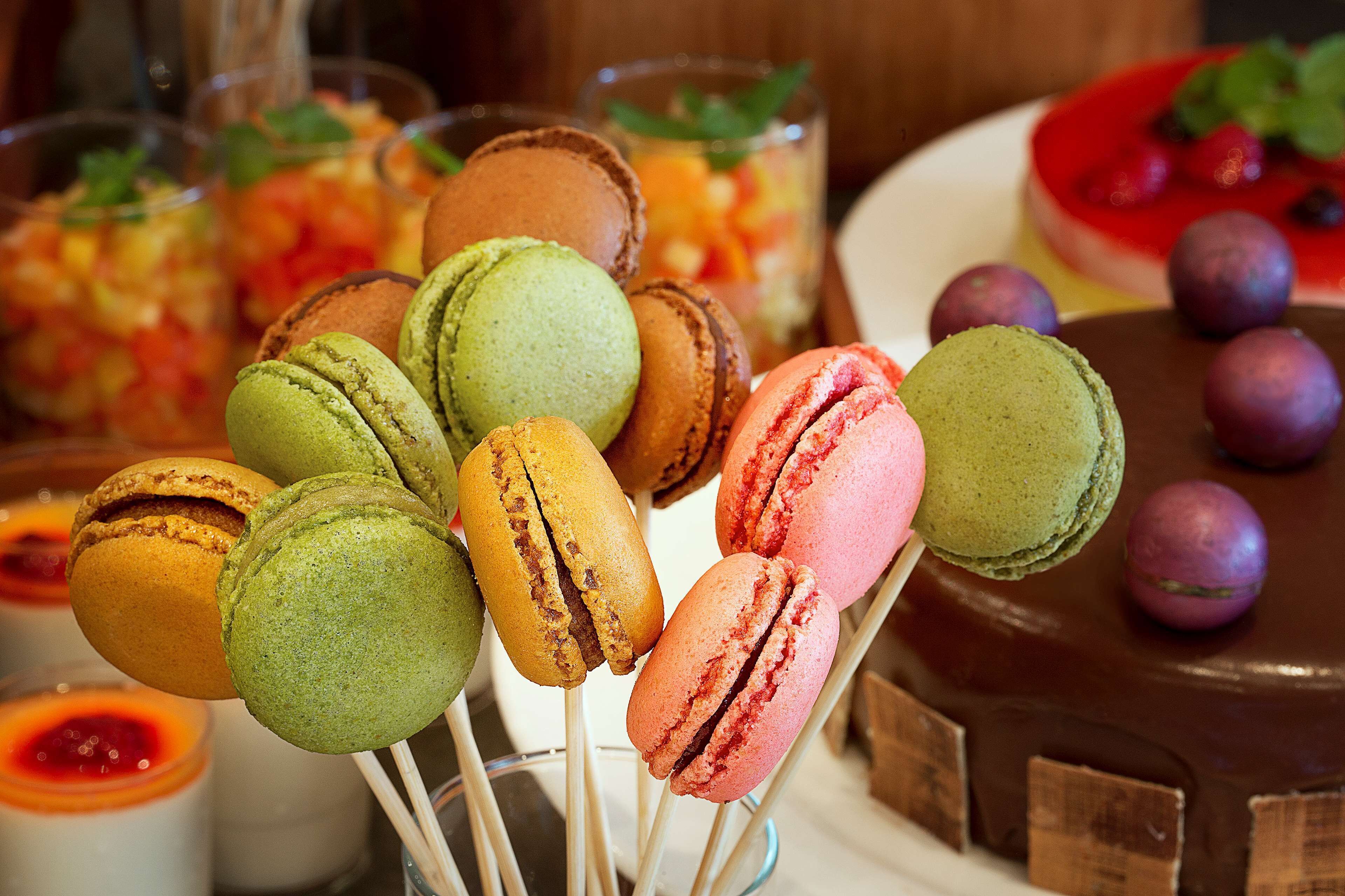 A dessert table with macarons and a chocolate cake.