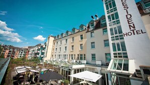 A hotel with a prominent 'President Hotel' sign, multiple floors, and a glass facade. - Best Western Hotel President (Bonn)