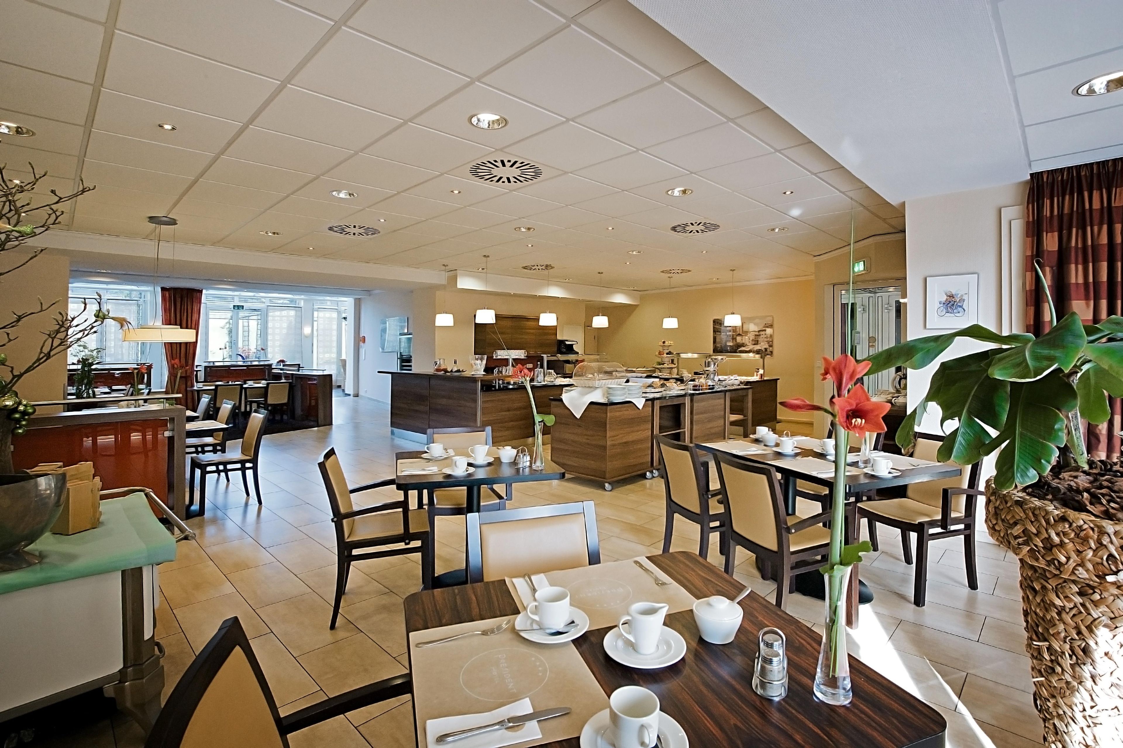 Un comedor de hotel con varias mesas, sillas y una barra central.