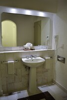 A bathroom with a sink, mirror, and towel rack.