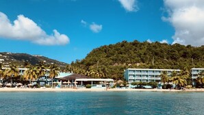 A beachfront hotel with multiple buildings, palm trees, and a clear blue sky. - Emerald Beach Resort (St. Thomas)