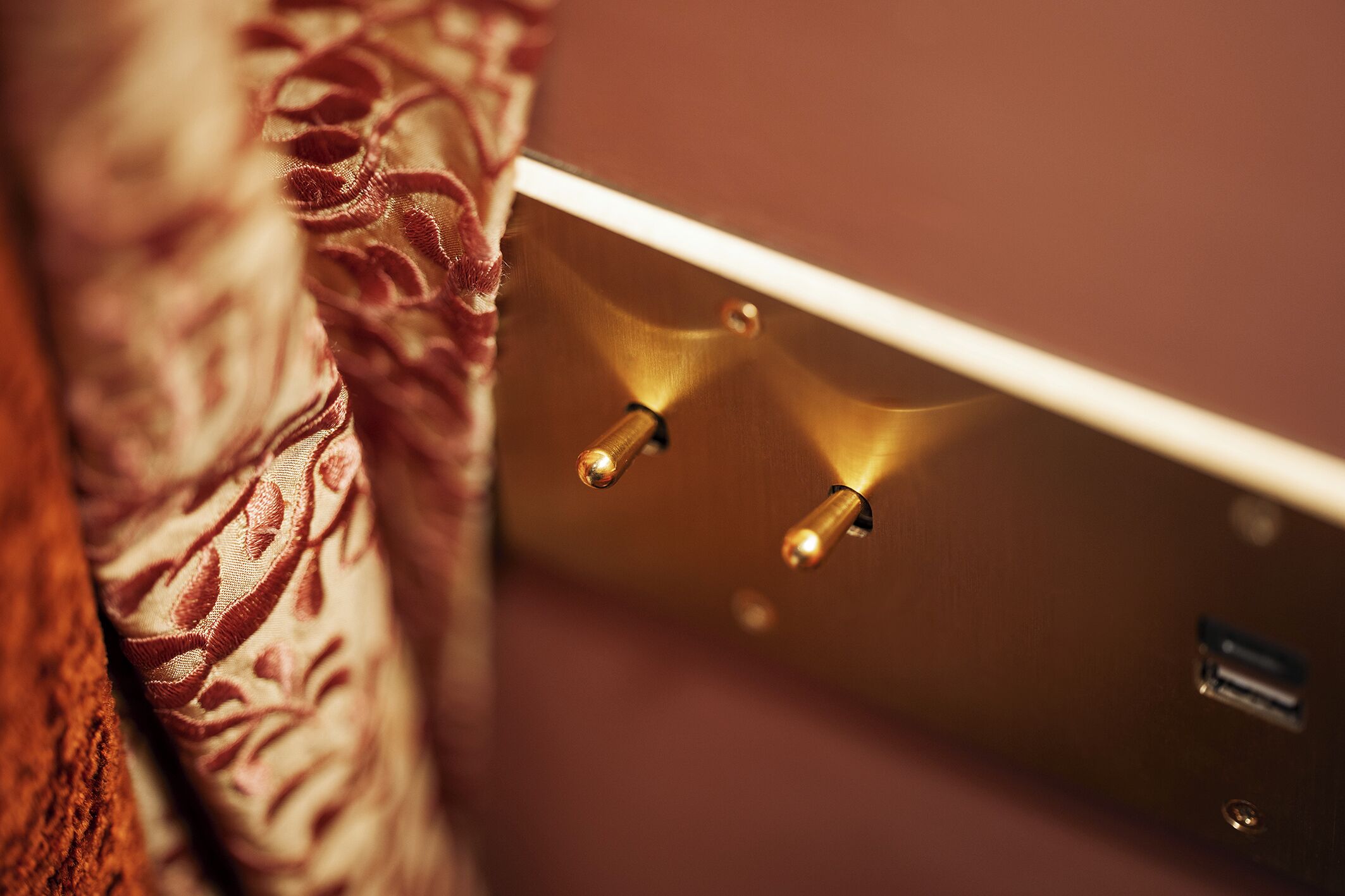 Detailaufnahme eines Lichtschalters mit zwei Tastern und einem USB-Anschluss an einer Wand.