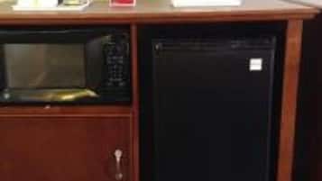 Een kitchenette met een magnetron en een kleine koelkast.