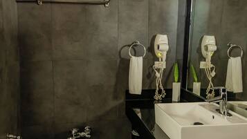 A modern bathroom with a toilet, bidet, and two sinks.