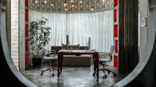 A conference room with a large table, chairs, a potted plant, and a curtain backdrop. - Riande Urban Hotel (Panama City)