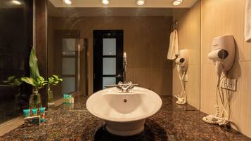 A bathroom with a sink, a hairdryer, and a mirror.
