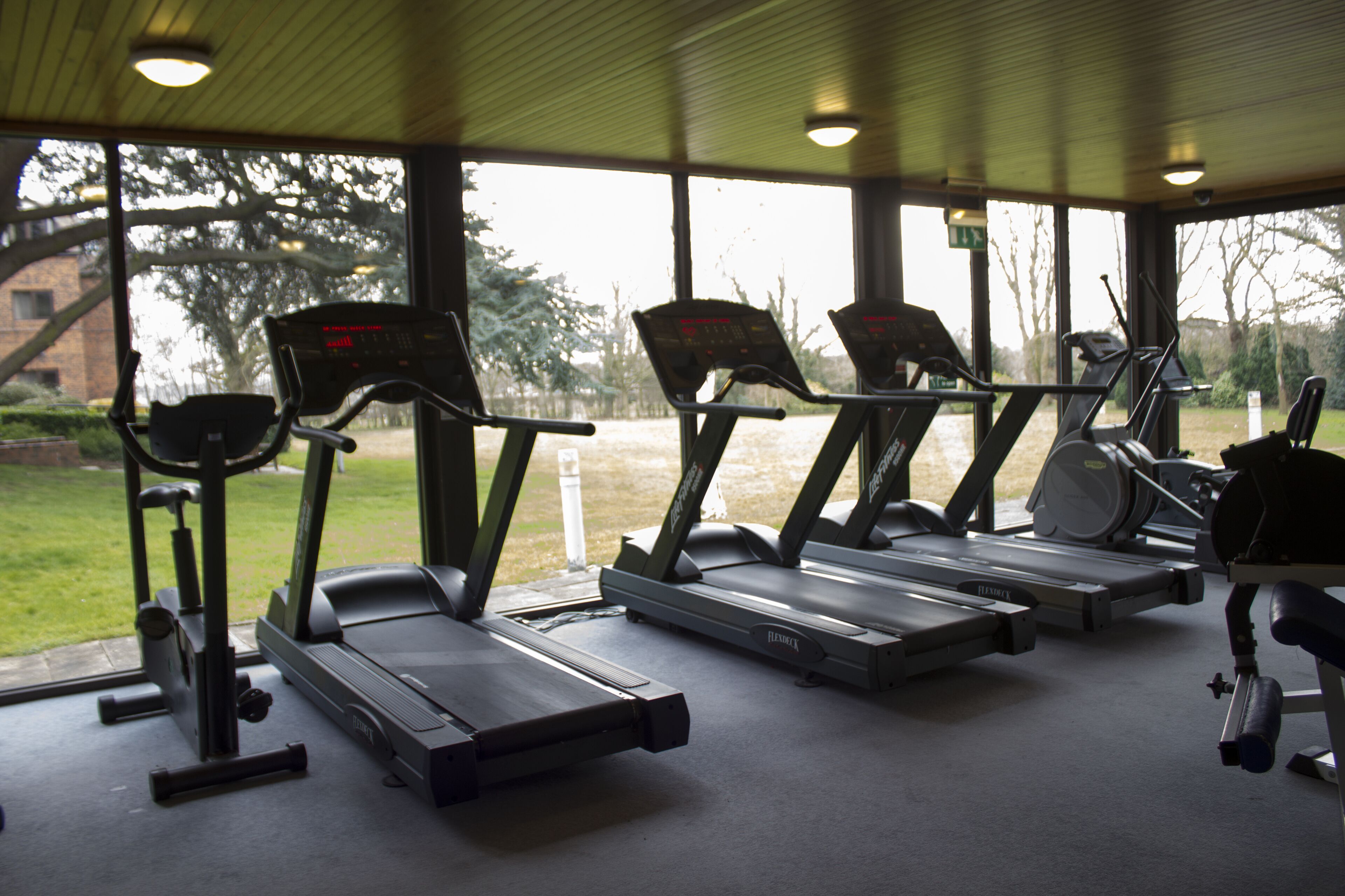 Une salle de sport équipée de tapis de course et d'appareils d'exercice.