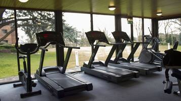 Une salle de sport équipée de tapis de course et d'appareils d'exercice.