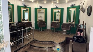 Un salón con múltiples espejos, suelo de madera y plumas decorativas de pavo real.