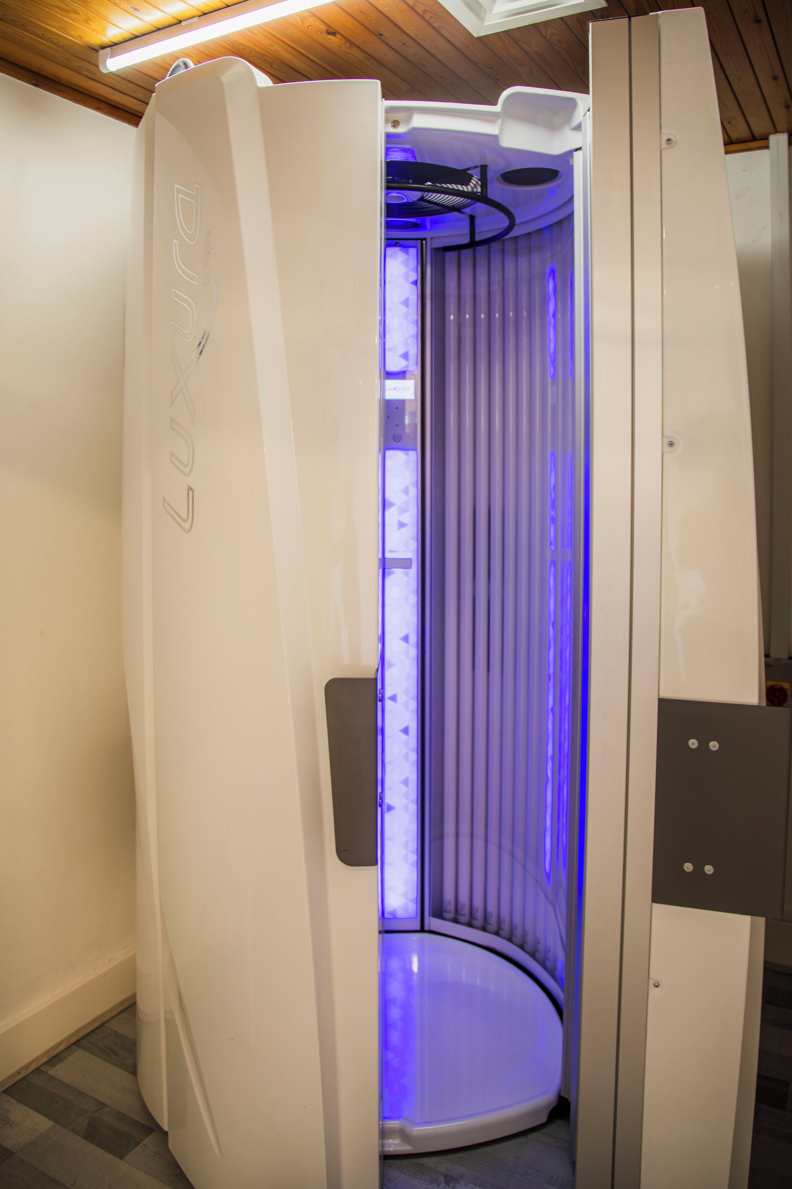 A modern, enclosed room with a curved ceiling and a visible control panel on the right.