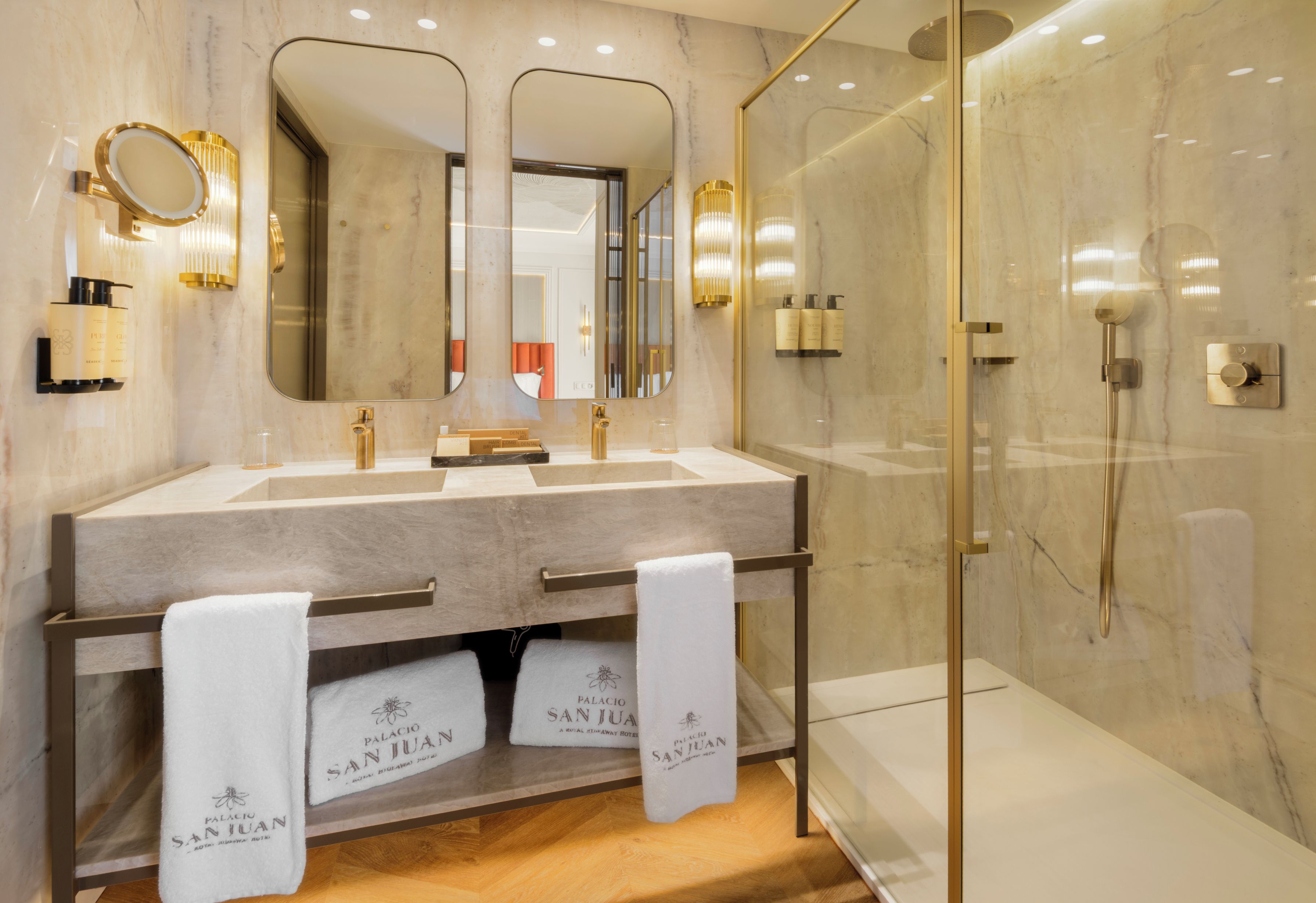 Un baño con lavamanos doble, un espejo grande y cabina de ducha con paredes de vidrio.