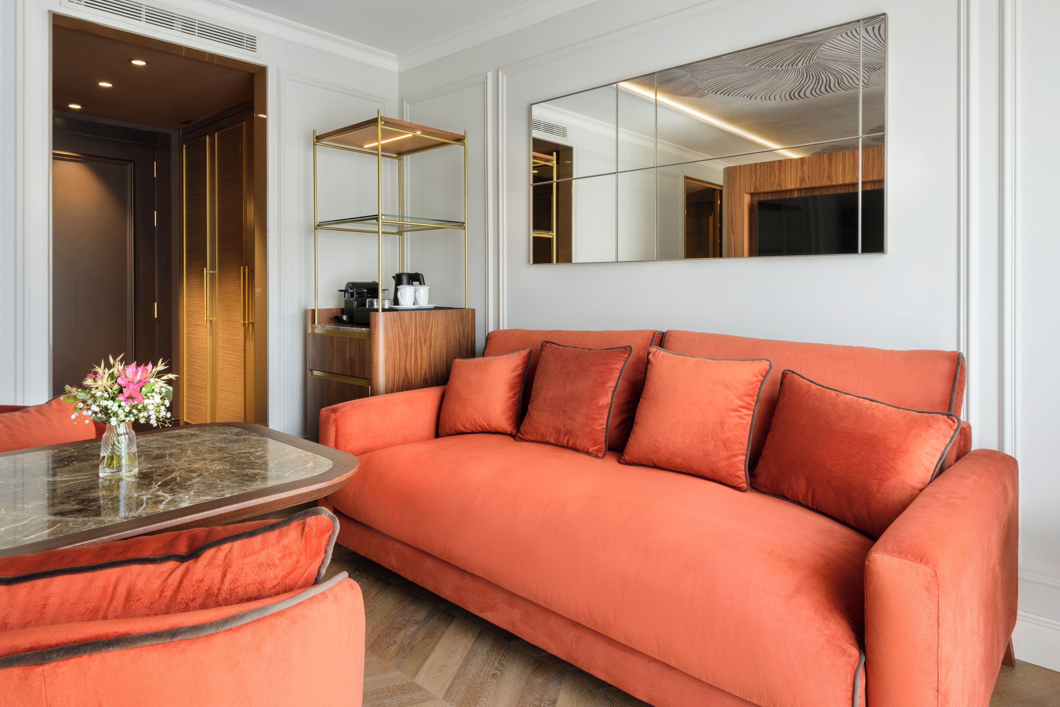 Una sala de estar moderna con un sofá, una mesita de centro y un jarrón decorativo.